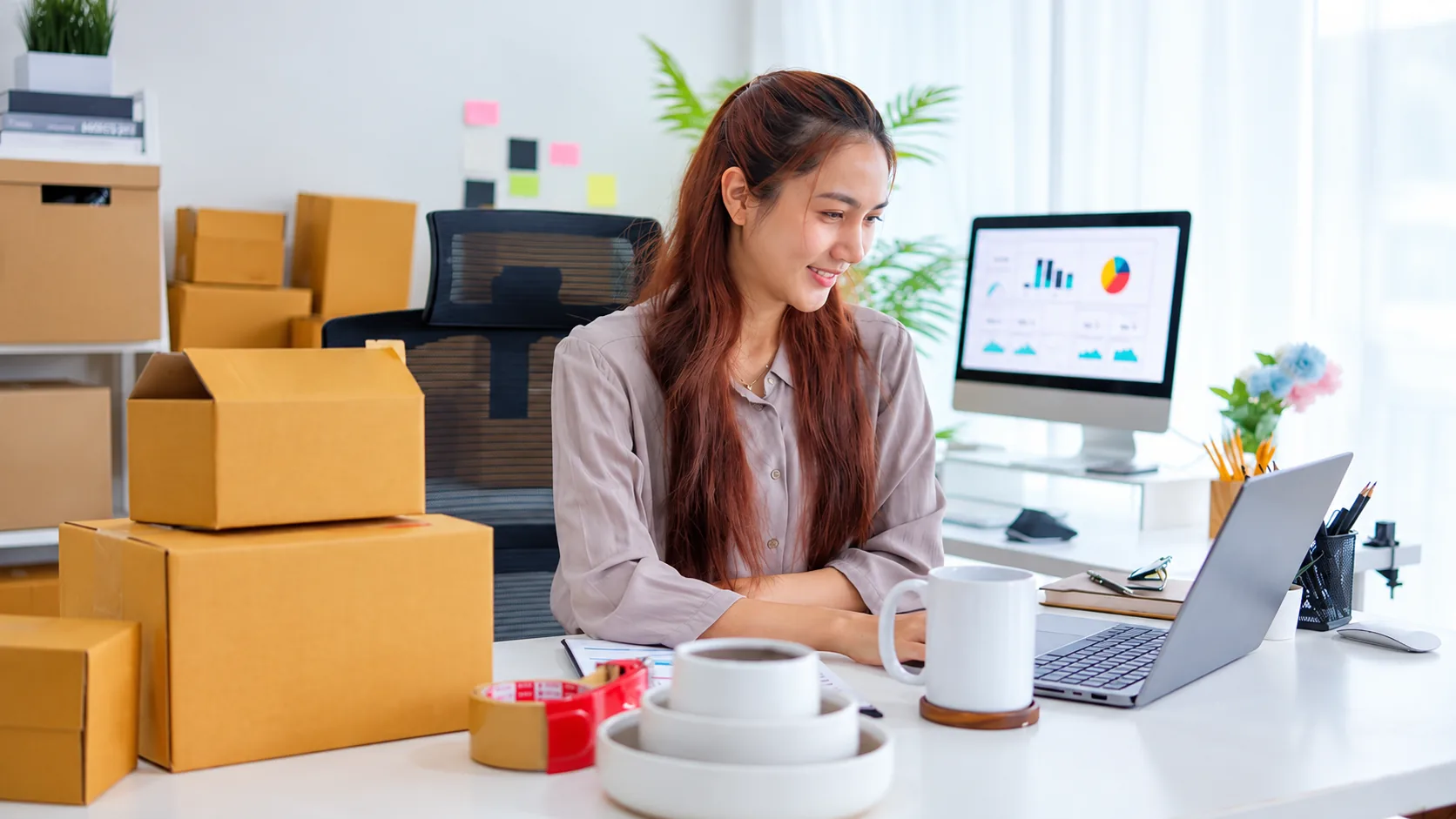 Online seller reviewing marketplace performance beside prepared packages